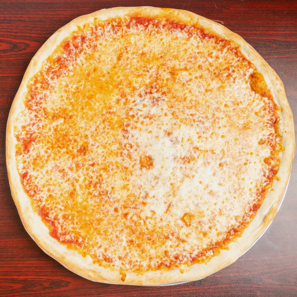 Large cheese pizza with golden melted cheese and tomato sauce on a thin crust, photographed on a dark wooden table.